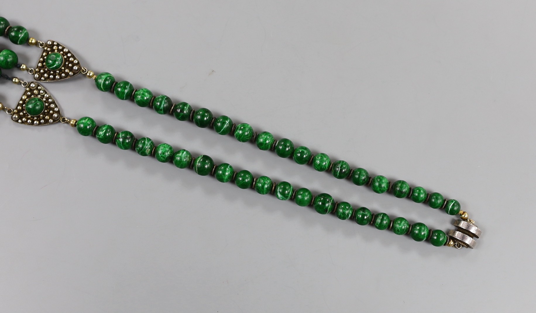 A 20th century Chinese single/double strand malachite bead necklace, with white metal clasp and triangular motifs, stamped 'China Liu Silver', 67cm.